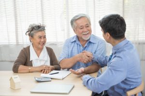 man giving handshake to old couple